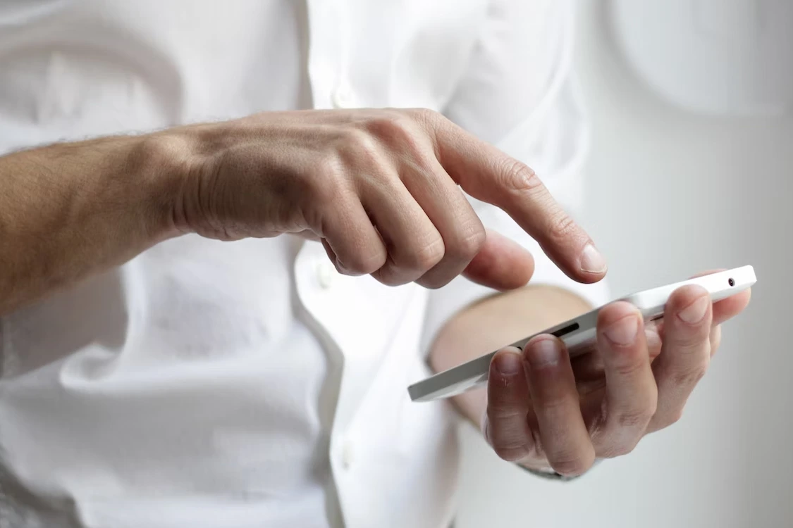 Mannenhand met telefoon in hand neemt contact op bij tekortkoming.